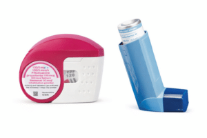 Pink and white combination MART inhaler beside a blue salbutamol reliever inhaler on a white background.