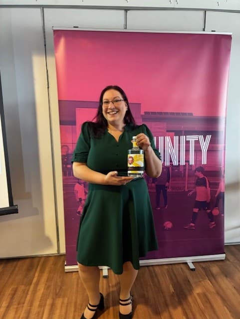 Stephanie Austin holding a bottle of FC United Red Rebels gin won in the raffle at the North Manchester International Women’s Day Business Awards.