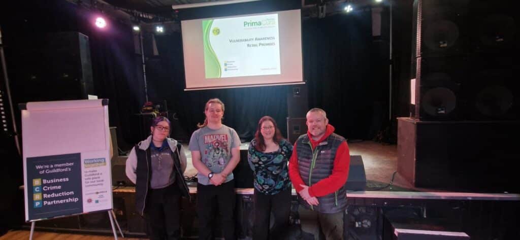 Guildford WAVE training participants with Business Crime Reduction Partnership signage and trainer