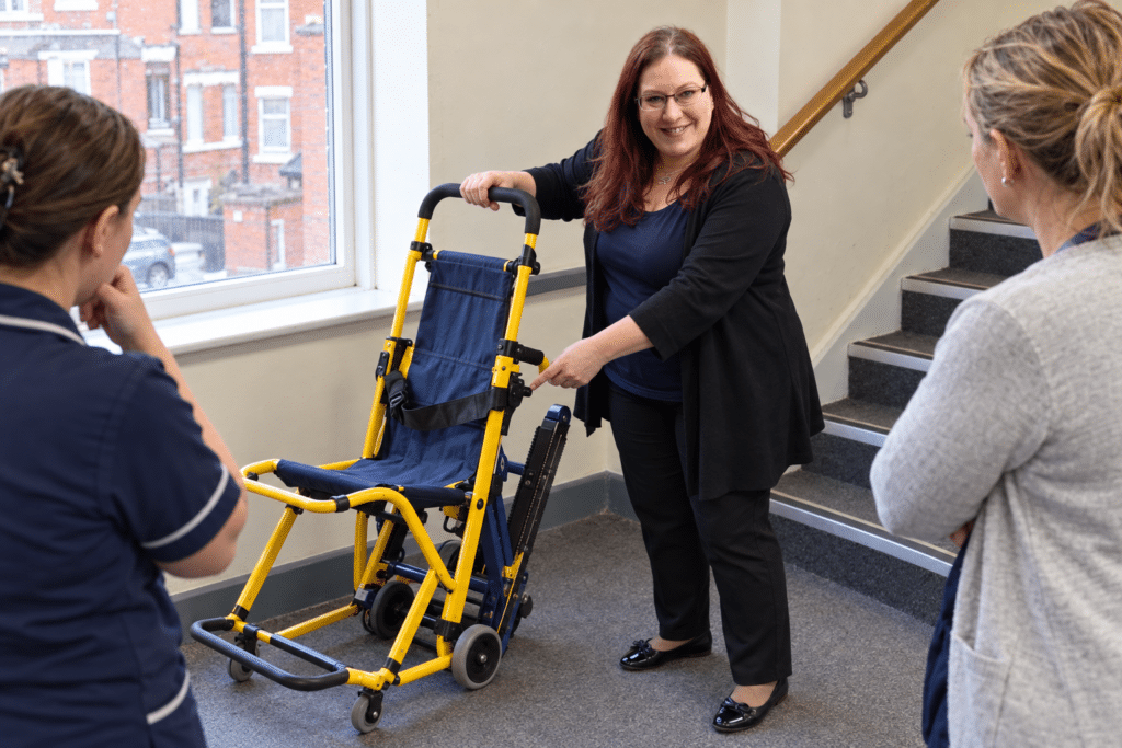 Care home staff practising evacuation chair technique during fire safety training delivered by Prima Cura Training in Greater Manchester