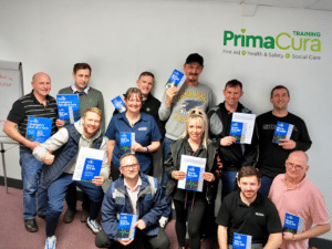 Group photo during on-site first aid training by Prima Cura Training at a Manchester workplace